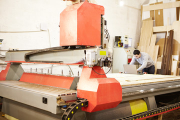 Cnc machine at carpentry workshop. Cutting wood with various router bits.