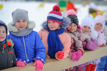A group of children playing and having fun on a winter playground. Winter fun. holidays
