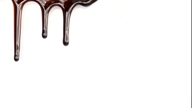 Real chocolate streams flows down on white background. Liquid chocolate. Seamless looping