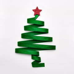 Stylized Christmas tree made from green ribbon with red shiny star on white background