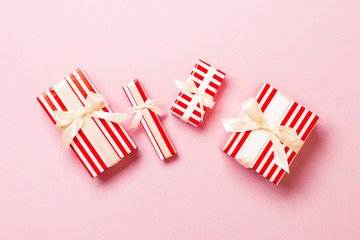 Fototapeta premium Top view Christmas present box with yellow bow on pink background