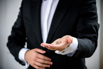 Two wedding rings on groom s hand during ceremony. Groom wear black festive expensive suite. Make proposition to bride