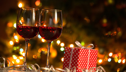 Glasses of wine and Christmas balls on the background of Christmas lights