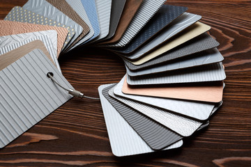 Samples of metal laminate laid out in the form of a circle on a brown Board