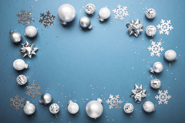 Merry Christmas and Happy Holidays greeting card, frame, banner. New Year. Noel. Christmas white, silver .ornaments on blue background top view. Winter xmas holiday theme. Flat lay