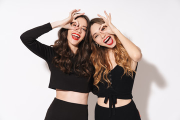 Portrait of two funny women smiling and gesturing ok sign