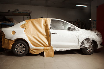 Garage painting car service. vehicle cover with protective paper before painting.