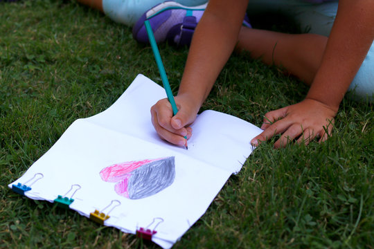 La fille dessine dans le jardin