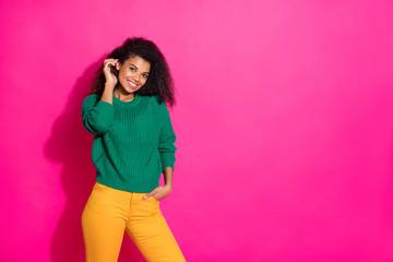 Portrait of cheerful positive afro american girl enjoy free time with her friends in autumn fall listen feel content wear green pullover trousers isolated over pink color background