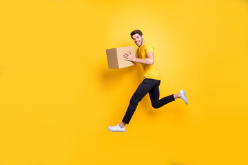 Full size photo of handsome guy jumping high holding parcel box hurry move new apartments...