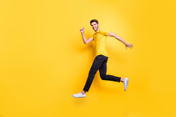 Fototapeta na wymiar Full length body size view of his he nice attractive sportive cheerful cheery guy running fast motivation isolated over bright vivid shine vibrant yellow color background