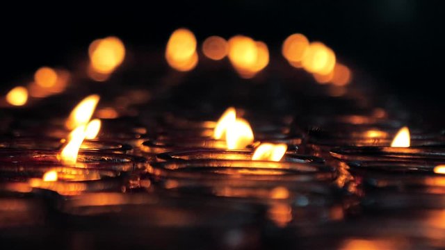 Close-up slow motion shot of a candles burning in a Buddhist temple., China.