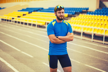 happy bearded male athlete is training in the stadium