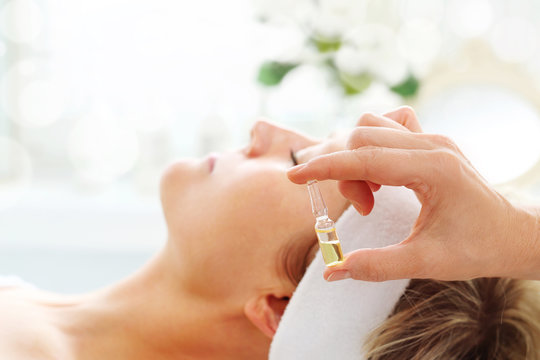 Care Treatment In A Beauty Salon. The Beautician Applies A Cosmetic Preparation In An Ampoule