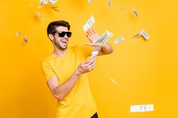 Photo of young handsome careless guy throwing money banknotes away wealthy person wear sun specs...