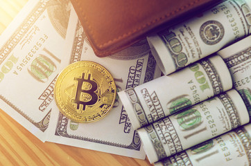 golden bitcoin and us dollar bill on wood table in home office.Bitcoins and New Virtual money concept.