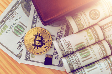 Obraz premium golden bitcoin and us dollar bill on wood table in home office.Bitcoins and New Virtual money concept.