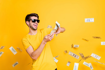Portrait of his he nice attractive glad cheerful cheery guy throwing away large sum of money budget...