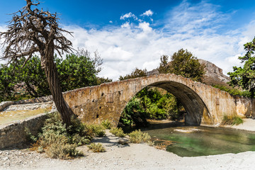Fototapeta na wymiar Medieval stone bridge over a mountain river