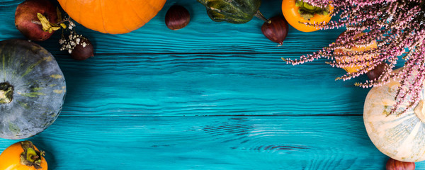 Autumn thanksgiving moody background with different pumpkins, fall fruit and flowers on rustic...