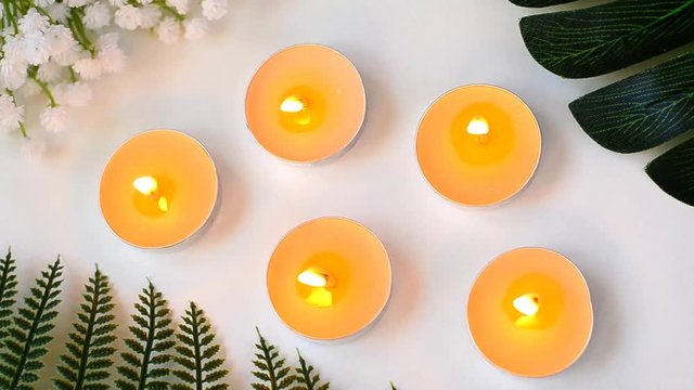 Five burning candles on white background flat lay top view
