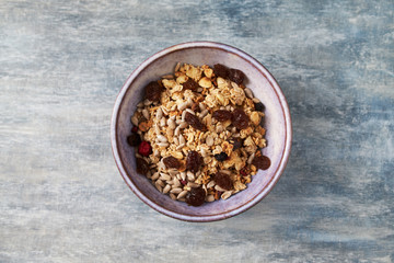 Bowl of granola. Concept for a tasty and healthy meal. Rustic wooden background. Top view. Copy space. 