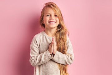 Portrait of positive cheerful girl cutely smiling at camera, girl with long golden hair in white...