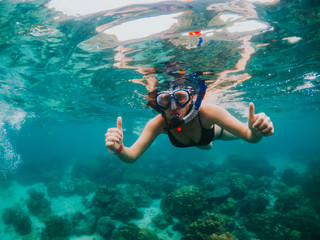 Obraz na płótnie Canvas Young woman snorkeling on tropical beach. Underwater sports and tropical vacation concept. 