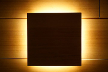Wooden wall as a background with a dark backlighted square