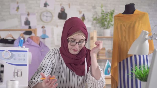 Young muslim woman fashion designer in National headscarf has difficulty with ideas, no inspiration
