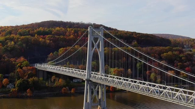 Aerial orbiting Mid-Hudson Bridge with colorful Autumn foliage Upstate NY