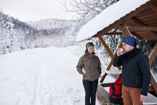 Smiling Young Couple Drinking Coffee During A Winter Hike