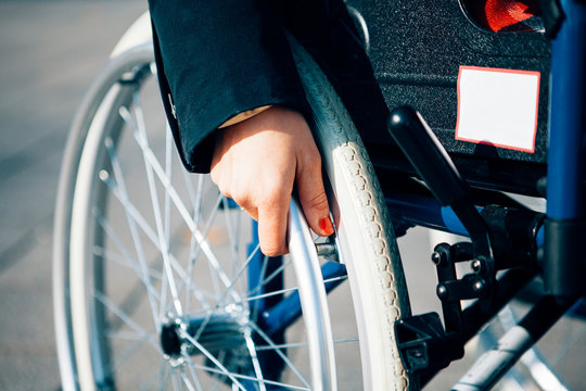 close up of a female hand holding a wheelchair - life with a disabilty concept