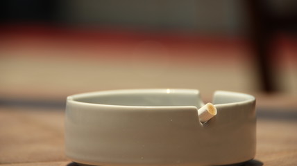 cigarette ashtray on the table, in a photo with a blurry background and selective focus