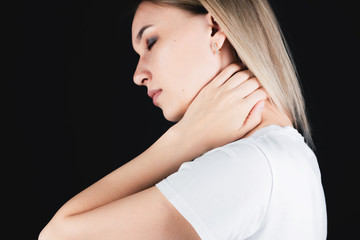 Portrait of a girl who holds on to the neck with hands experiencing pain.