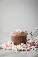 Heiße, dunkle Trinkschokolade mit Sahne und Marshmellows auf Marmor hell Hintergrund 