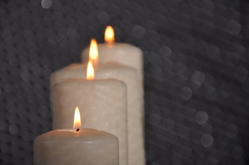 white candles in a white candlestick on a light background, place for text
