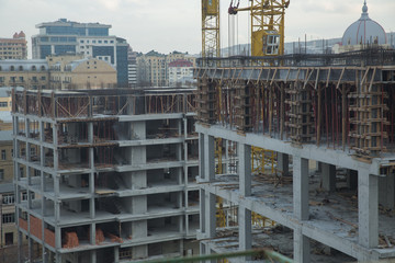 Large construction site including several cranes working on a building complex. Working on a construction site . New building is being constructed.