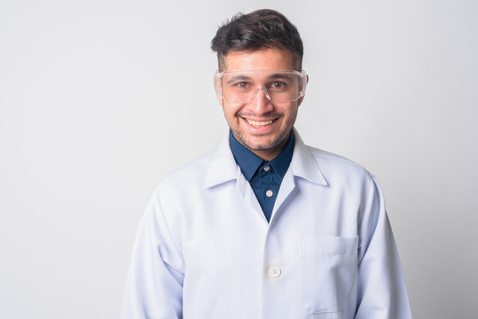 Face of happy Persian man doctor as scientist smiling