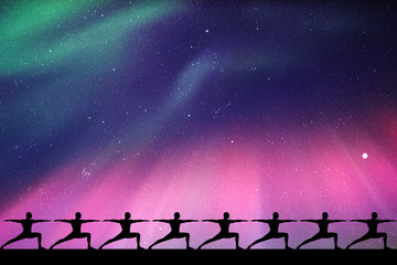 Naklejka premium Yoga at night. Seamless vector illustration with isolated silhouettes of yogis in warrior pose. Northern lights in starry sky. Colorful aurora borealis