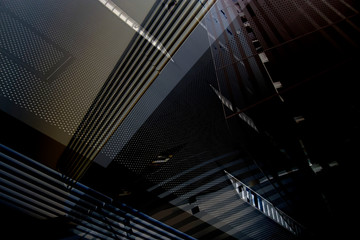 Collage photo of modern office architecture in darkness. Generic architectural elements. Grunge structure of building interior with lath ceiling and perforated metal panels.