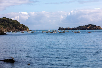 Fototapeta premium Fishing boats and yachts moored in the bay at high tide in Cancale, famous oysters production town. Brittany, France,