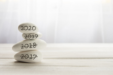 Stacked white stones on white background - Lifestyle and alternative health concept image with copy space for text.