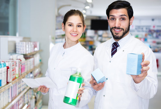 Two pharmacists posing in apothecary