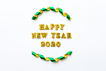 Simple happy new years 2020 text in gold lettering and curled ribbon isolated on white background