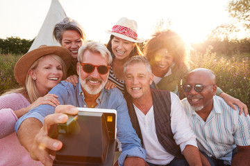 Group Of Mature Friends Posing For Selfie At Outdoor Campsite
