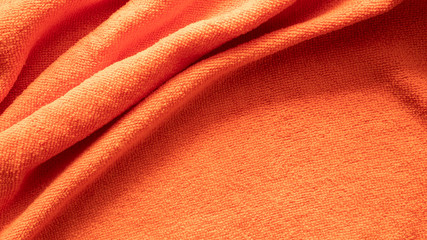 Orange towel textured background, soft fabric towel in spa bathroom, selective focus.