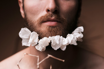 A bearded man with a decorated beard for the Spring holiday. Flowers in the beard.