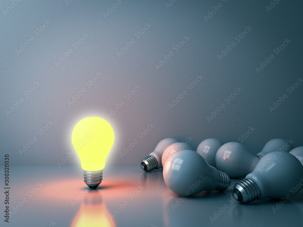 Leinwandbilder one glowing light bulb standing out from the unlit incandescent bulbs in the dark room background wi