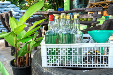 bottles of green gasoline for sale to motorcyclists in a fruit crate. Illegal sale of petroleum...
